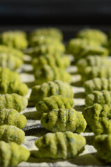 rows of fresh green gnocchi on a plate