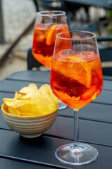 2 glasses of aperol spritz on the table, chips next to it