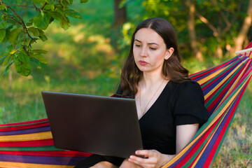 woman with laptop on hammock.online training.young woman boss with laptop.serious woman boss.feminism.self-sufficient.businesswoman.online conference.work on vacation.focused girl. work from home.
