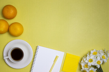 Yellow theme with orange, notebook, coffee, flower and a copy space. 