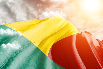 Benin national flag cloth fabric waving on beautiful Cloudy Background.