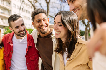 Young group of diverse student people having fun outside. Multiracial teenage friends laughing enjoying time together on summer days. Youth community and friendship concept.