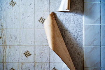 Foil with artificial tiles detaches from the kitchen wall in an old apartment in need of...
