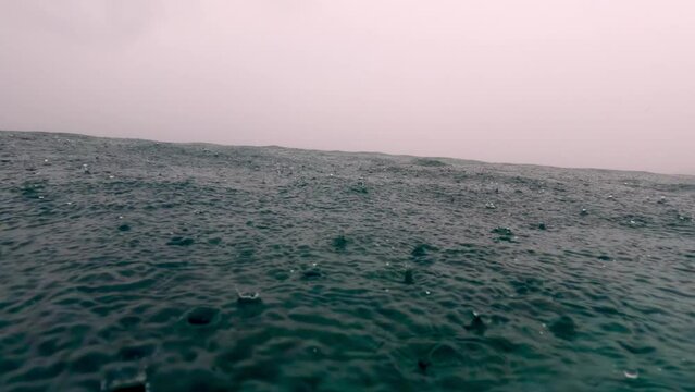 Beautiful Rain in Sea Storm in Horizon. Rain Dropping into Endless Sea. Raindrops Fall Calm Surface Ocean. Sense of Serenity and Beauty Found in Simplest Natural Phenomena. Monsoon season Slow Motion