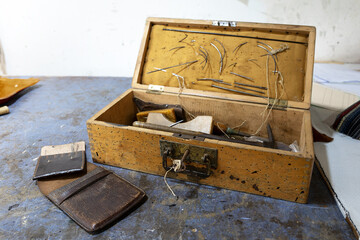 Old wooden toolbox from an upholsterer with needles and various craft tools, used for work on the go, traditional craftmanship, copy space, selected focus