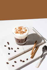 Café irlandés con crema batida y canela en un fondo gris