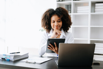 Business woman using tablet and laptop for doing math finance on an office desk, tax, report, accounting, statistics, and analytical research concept in office