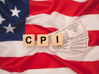 Naklejka premium Wooden cubes with the letters CPI on the American flag background.