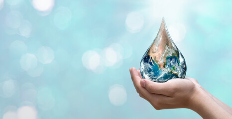 World water day. A globe in the shape of a drop of water falling onto the boy's hand on blue sea...