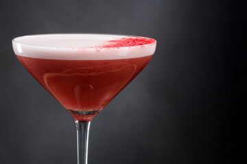 Refreshing low-alcohol cocktail with whipped juice and foam. Alcoholic refreshing cocktail in a glass with foam on a black background, frothy drink. Copy space
