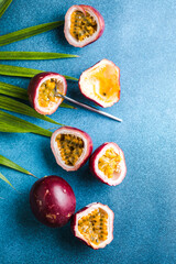 Ripe passion fruit, half and slice of fruit on a blue background.