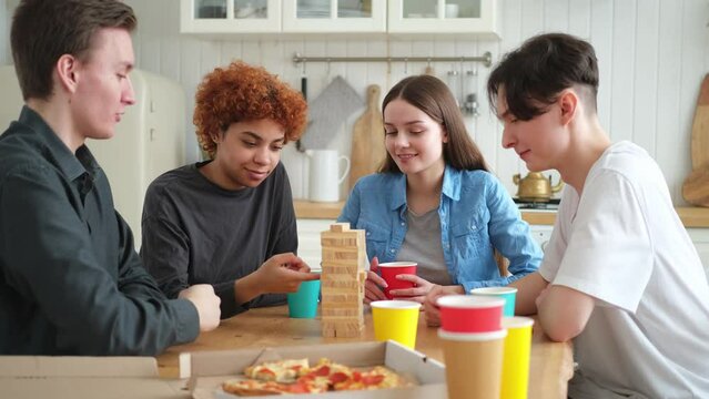 Home Party. Friends Spending Time Together Playing In Board Game Crash Wooden Tower At Home. Happy Diverse Group Having Fun Together Indoor. Mixed Race Young Buddies Best Friends Enjoying Weekend