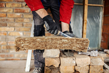 Close up of a housebuilder cutting insulation on a building area.