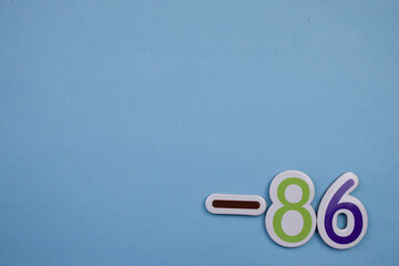 The number -86, written in color, placed on the edge of a blue background.