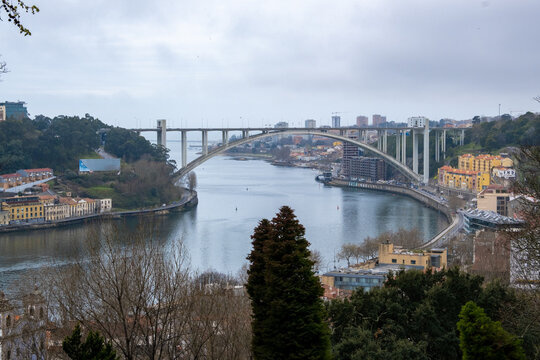 La belleza de Oporto, Portugal, con el emblemático puente de Don Luis como protagonista. En la imagen, el puente de hierro se extiende majestuosamente sobre el río Duero, conectando las dos orillas de