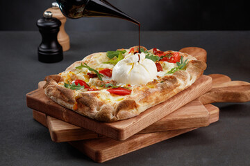Roman pizza with buratta cheese with pouring balsamic sauce, sweet red peppers, cheese and arugula...