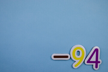 The number -94, written in color, placed on the edge of a blue background.