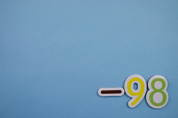 The number -98, written in color, placed on the edge of a blue background.