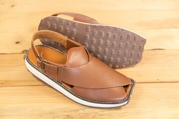 Peshawari sandal use as a formal or casual footwear in summer on wooden background closeup.