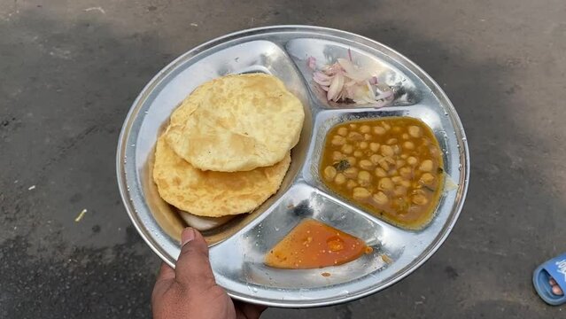 Chole Bhature Old Delhi Street Food held in hand at a roadside shop in India.