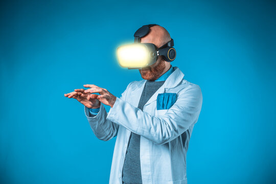 Photo of male doctor with 3d glasses with blue background and medical white coat