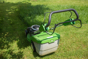 Fototapeta premium mowing the grass in the home garden with a gas lawnmower