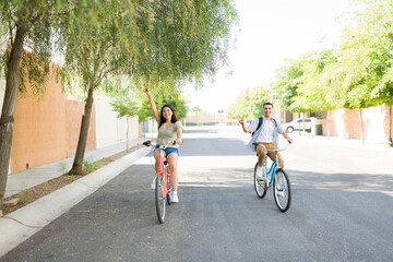 Caucasian couple having fun making the peace sign going on a bike ride