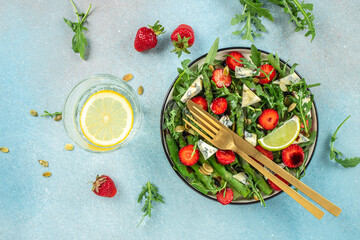 Healthy Green Salad Leaves, Slices of Fresh Strawberries. Concept healthy and balanced eating. place for text, top view