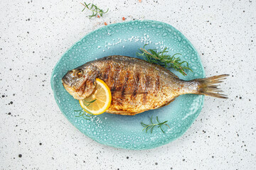 Grilled dorado fish with lemon on a light background. Concept healthy and balanced eating. place for text, top view