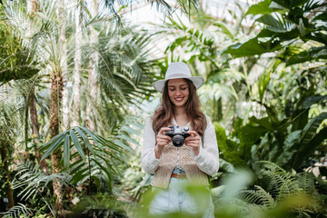 Portrait of beautiful woman photographer in botanical garden.