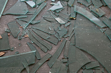 Cracked broken destroyed glass abstract texture on the cement floor background at Thailand.    