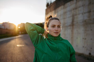 Young woman in sportive clothes resting outdoor.