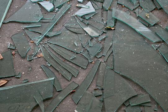Cracked broken destroyed glass abstract texture on the cement floor background at Thailand.    