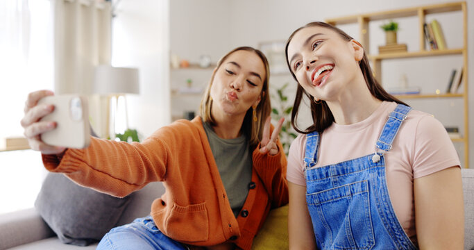 Selfie, happy and women or friends on sofa for social media update, influencer post or digital memory with emoji face. Young, gen z people in profile picture or photography online and peace hand sign