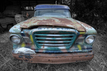 A frontal photo of an old rusty and abandoned American pick up truck 