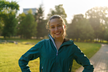 Portrait of smilling fitness woman excercising in the city park in the early morning.