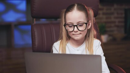 Little professional business lady sitting in executive chair in front of laptop and analyzing marketing on internet. Pensive girl in spectacles holding hand under chin and thinking on project plan. - Powered by Adobe