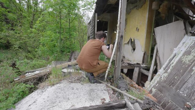 Male photographer on assignment at ruins of a building captures photos
