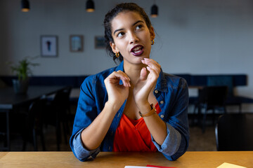 Happy biracial casual businesswoman talking during video call at desk
