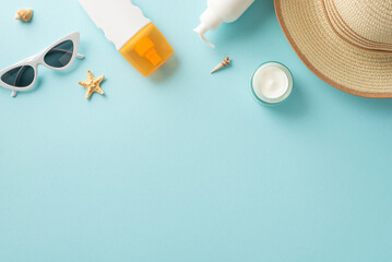 July is UV safety awareness month: sunscreen bottles, sunglasses, sunhat, shells, starfish, on a pastel blue background. A blank space adds a personalized touch for text or advertising