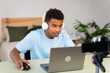 Male streamer recording tutorial from home.