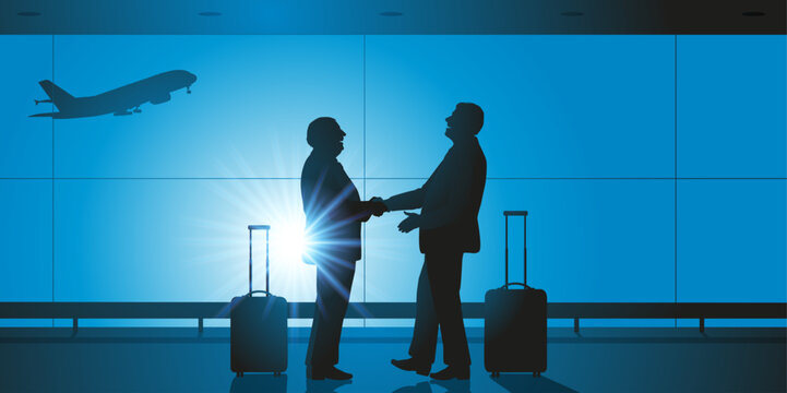 Concept du voyage d’affaires, avec la poignée de main entre deux chefs d’entreprises dans le hall d’un aéroport, avant d’embarquer dans leurs avions.