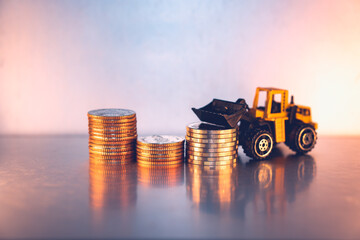 Closeup stack coins with forklift vehicle using as business and logistics industry concept