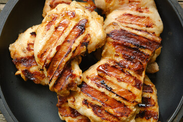 Grilled juicy chicken thigh fillets closeup. View from above. - obrazy, fototapety, plakaty