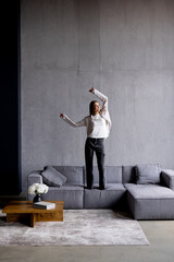 Portrait of woman dancing, rejoicing and triumphing, feeling upbeat at home. Copy space