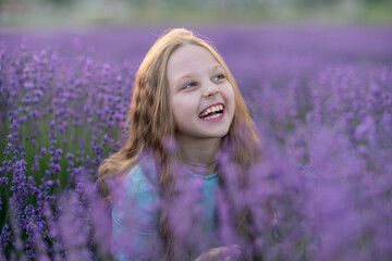 Girl lavender sunset. Girl in blue dress with flowing hair walk on the lavender field.