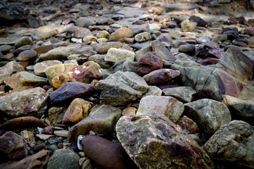 Fototapeta na wymiar Rocky bottom with dry riverbed with autumn weather background in nature and small pebbles.