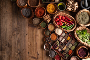 Fototapeta na wymiar Spices. Collection of spices in bowls on wooden rustic table forming an abstract background.