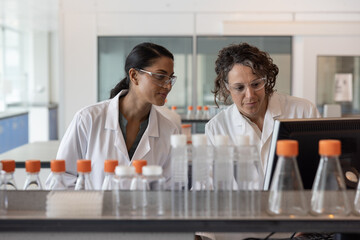 Female science student learning how to anaylse data on a computer in a laboratory