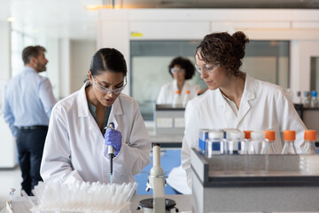 Female science student pipetting in laboratory 